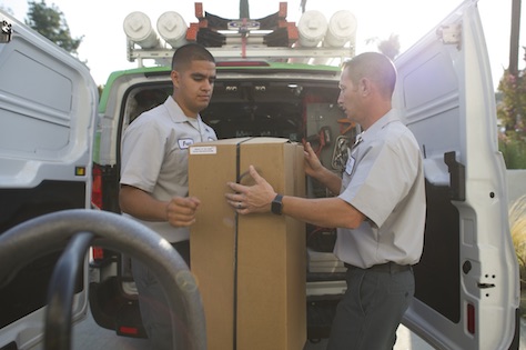 two men loading a box into the van